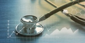 Stethoskop auf einem Tisch, darüber eine eingeblendete Statitsik