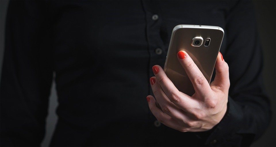 Frauenhand hält Smartphone