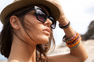 junge Frau trägt Hut und Sonnenbrille