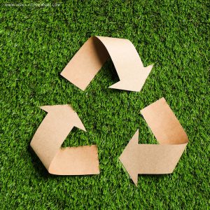 das offizielle Zeichen für Recycling aus Pappe auf Rasen