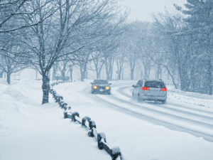 verschneite Landstraße mit zwei entgegenkommenden Fahrzeugen