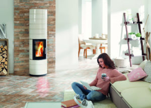 Frau sitzt auf dem Boden vor einem Gussofen