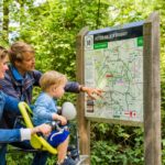 Familie mit Kleinkind vor einer Radwanderkarte