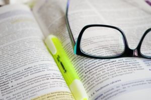Brille und Textmarker auf Buch