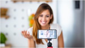 Handy auf Stativ filmt eine junge Frau